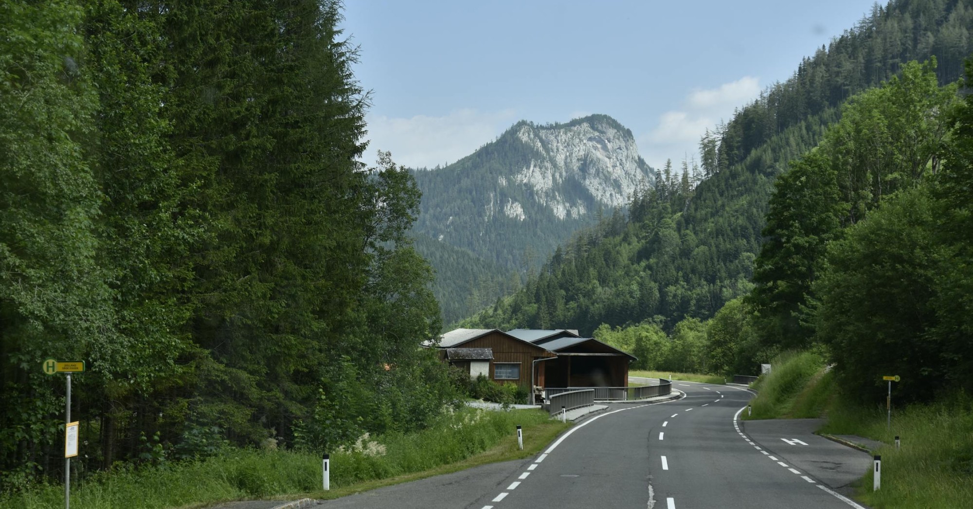 A rural road winding through forested mountains